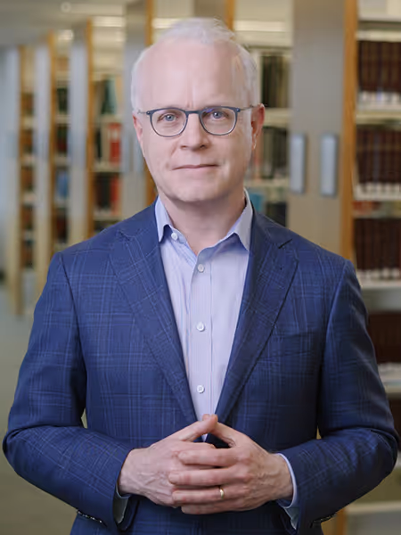 Perkins Coie Managing Partner Bill Malley standing in a library.